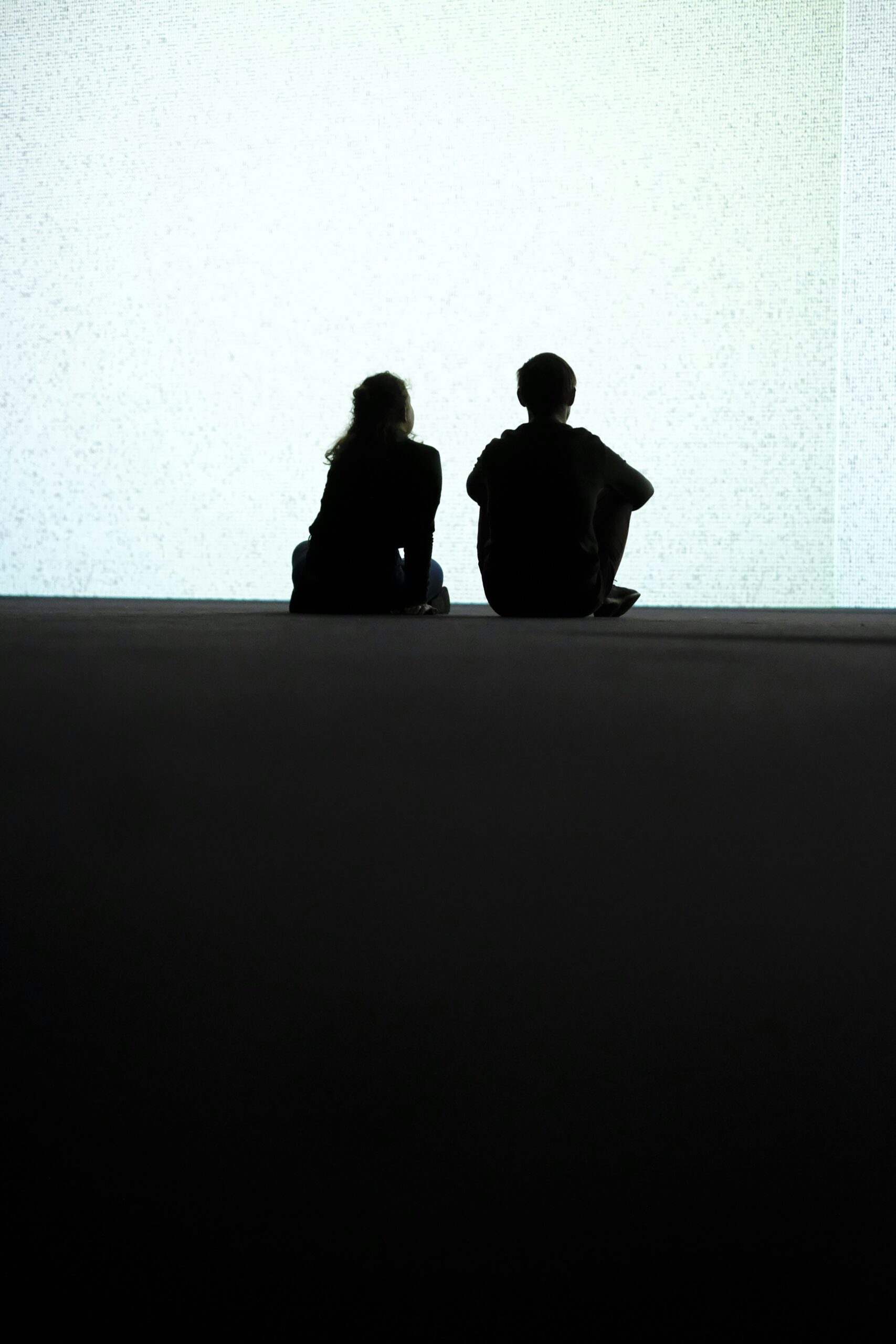 Couple in therapy session with a compassionate female therapist, discussing communication and relationship issues in a calm, neutral-toned office.