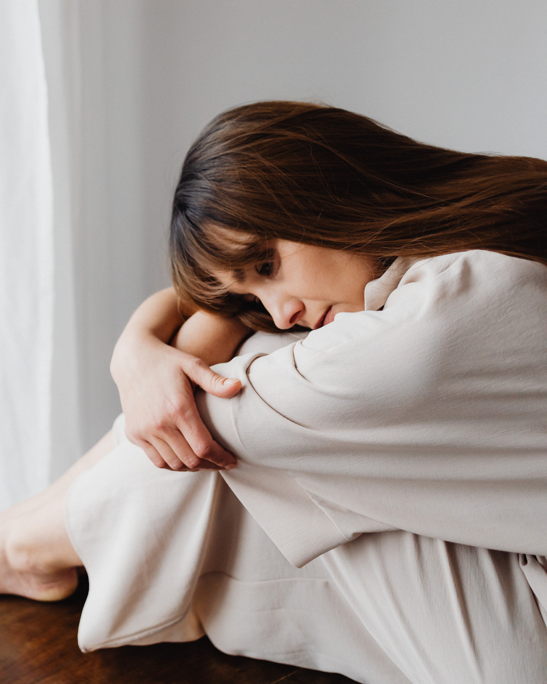 Woman sitting alone feeling overwhelmed by uncertainty and anxiety